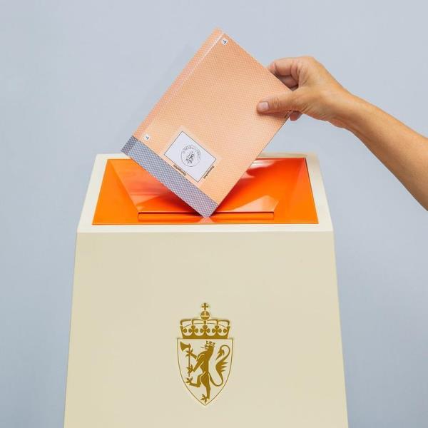 Foto av hand som legg stemmeseddel i valurne